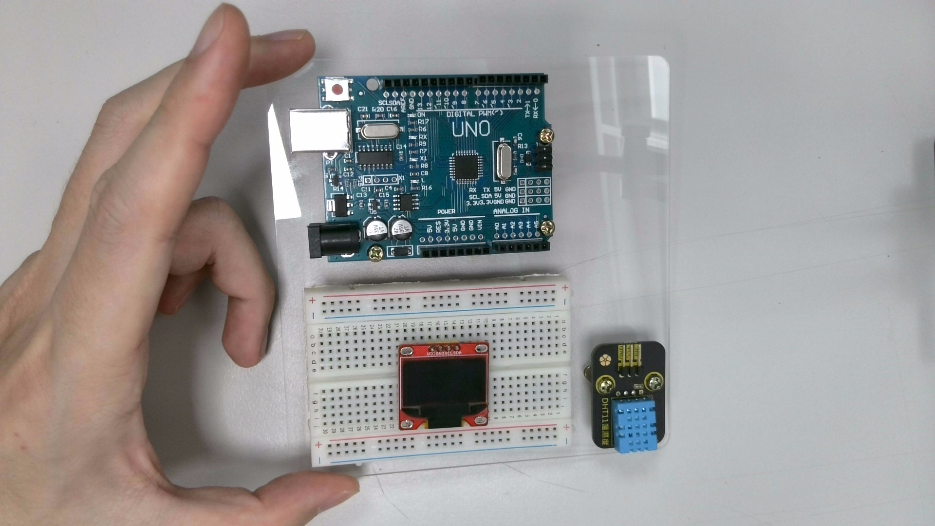 接著拿出「麵包板」,將背後的泡綿膠紙撕除,並黏貼在如下位置。同時將「OLED 顯示螢幕」也插上去。