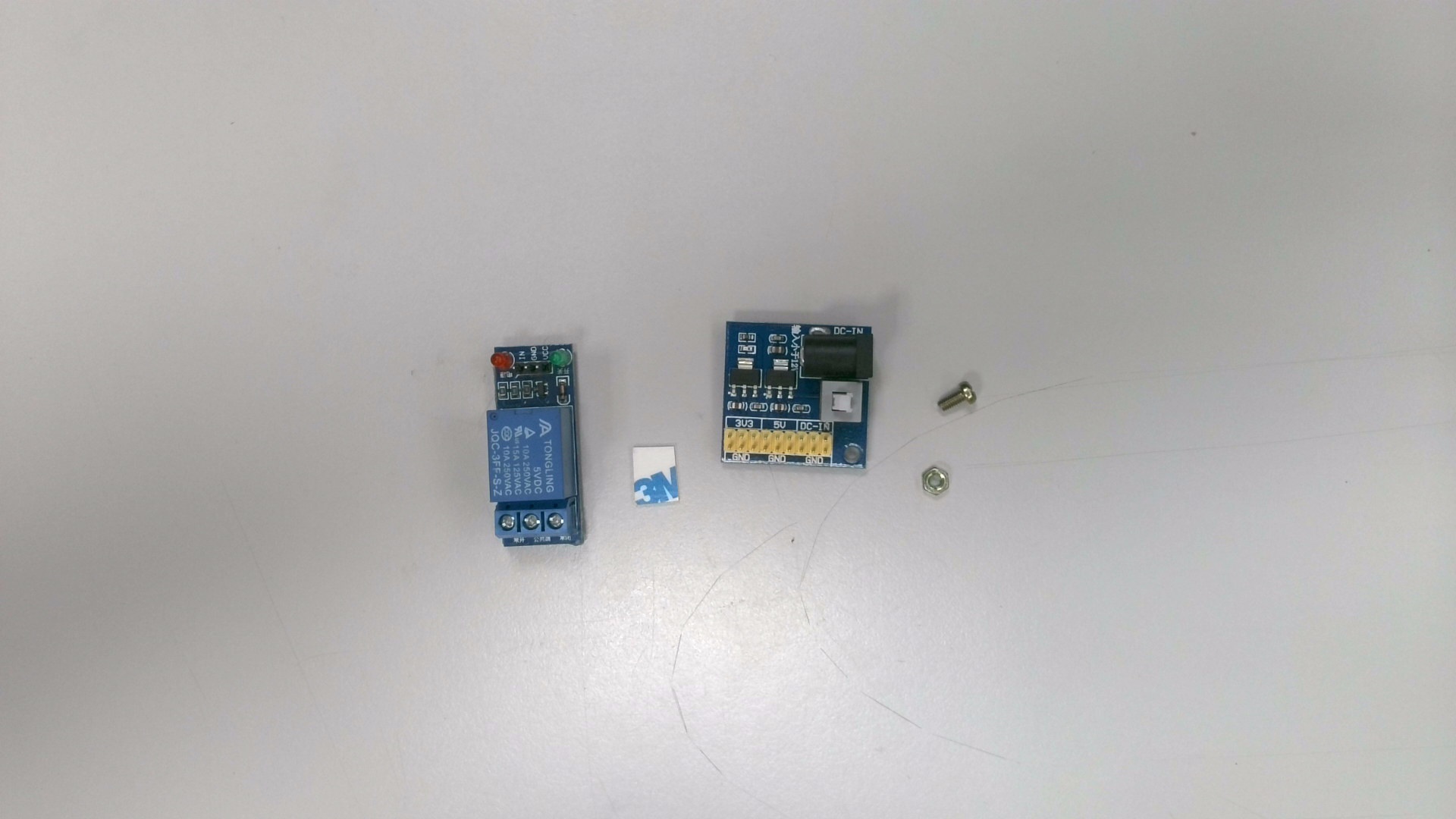 拿出「繼電器」、「多路 DC 電源轉換模組」、「M3螺絲 x1」、「M3螺母 x1」與「泡棉膠」。